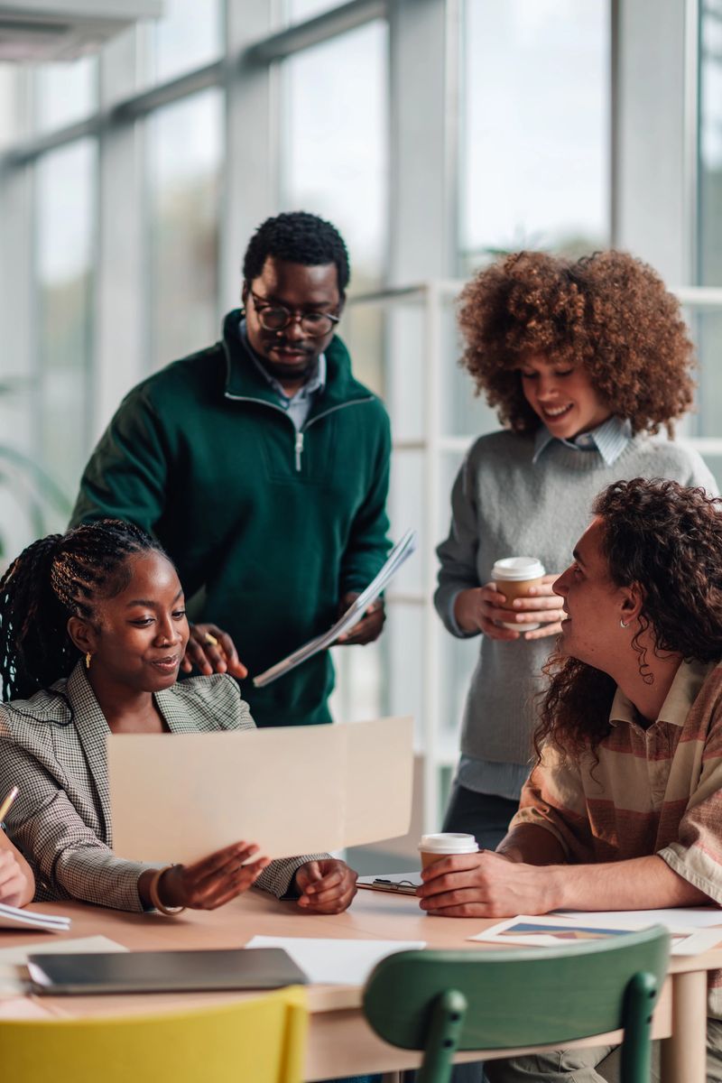 Group of multi-ethnic colleagues discussing project ideas and sharing insights while working together in a modern office