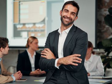 Businessman pointing at the word 'Compliance' surrounded by related terms and icons.