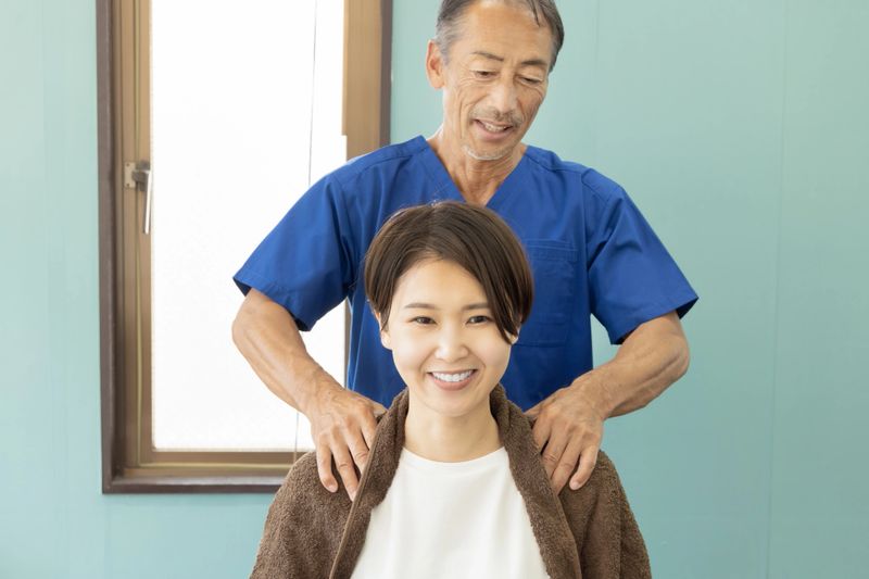 Senior male chiropractor giving chiropractic treatment to a young woman
