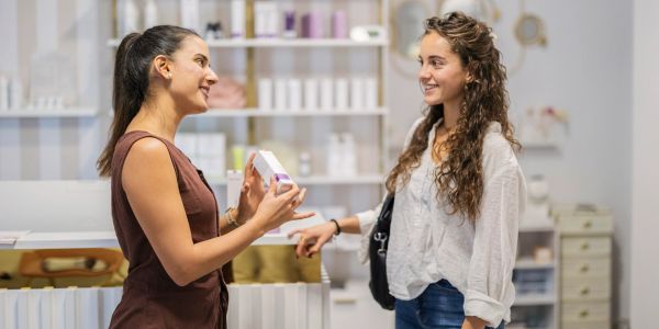 A saleswoman showing a product to a customer in a store.