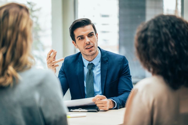A team of professionals collaborates over a contract during a business meeting. This image emphasizes the importance of negotiation and teamwork in achieving successful outcomes in a corporate environment