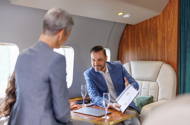 Business people having a discussion and reviewing data on a luxury private jet