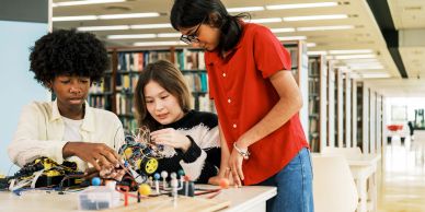 Three students working on a robotics project.