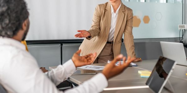Two business professionals engaged in a discussion in a modern office.