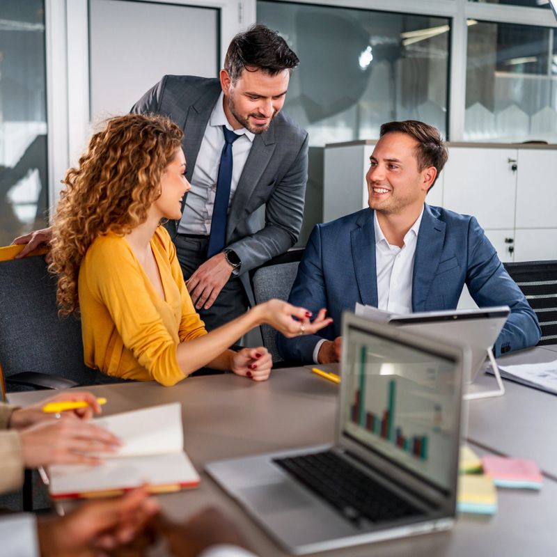 Three business professionals actively discussing new strategies and ideas while working together in a modern office