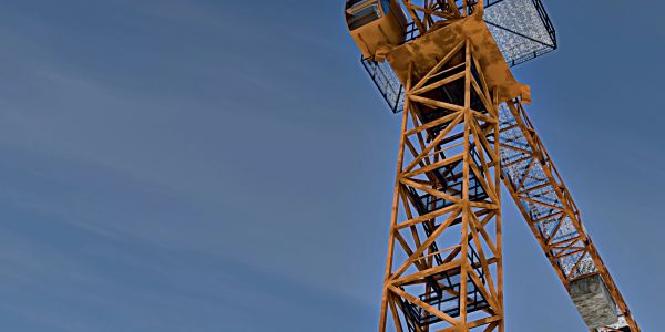 Close-up of an industrial crane against a clear sky.