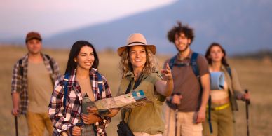 Group of friends hiking and using a map outdoors.