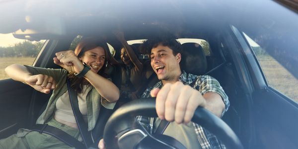 People in vehicle smiling on the road