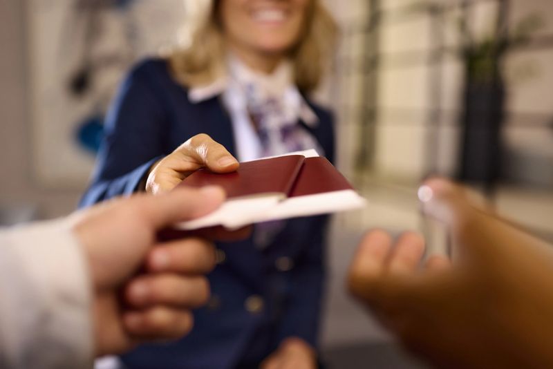 Close up of unrecognizable airline check-in attendant giving passports to her passengers at the airport.
