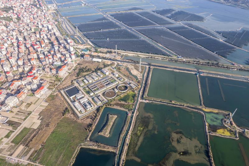 Aerial view of a solar power plant and wastewater treatment plant in a seaside village.