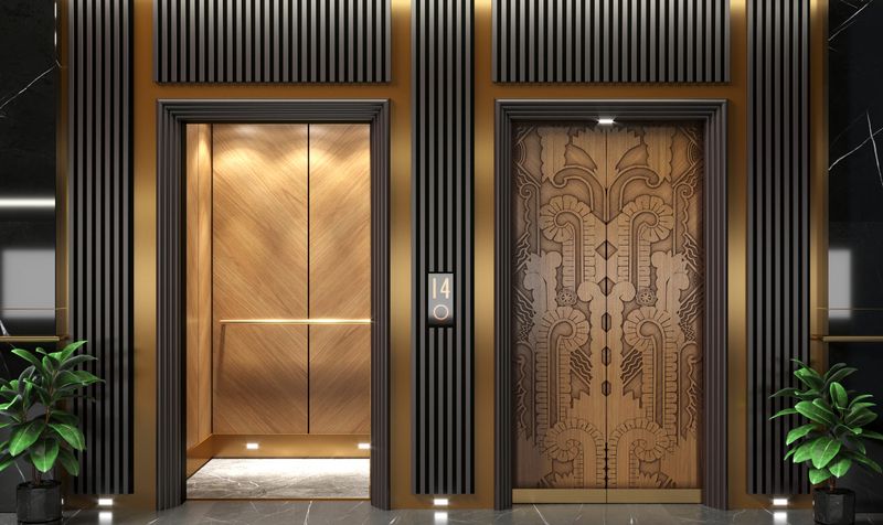 Luxurious Art Deco elevator lobby with elegant wooden doors, gold accents, and modern lighting, showcasing a stylish blend of classic patterns and contemporary design.
