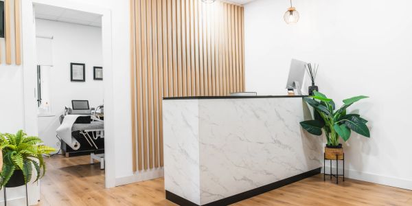 Modern reception area with marble desk and wooden floor.