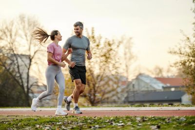 Couple jogging outdoors on a trail.