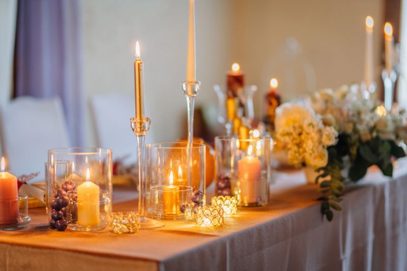 Beautifully arranged table features candles in glass holders, floral decorations, and a warm atmosphere, perfect for celebrations or intimate gatherings with friends and family