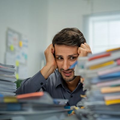 Stressed man overwhelmed with paperwork.