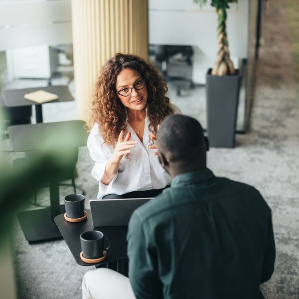 Two colleagues engaged in a focused discussion in a modern office.