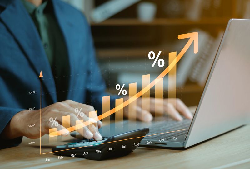 Interest rate concept, Business man using calculator with graph percentage symbol and up arrow, Growth of investments and profits, Dividends and long term investing to win Inflation, Calculate taxes