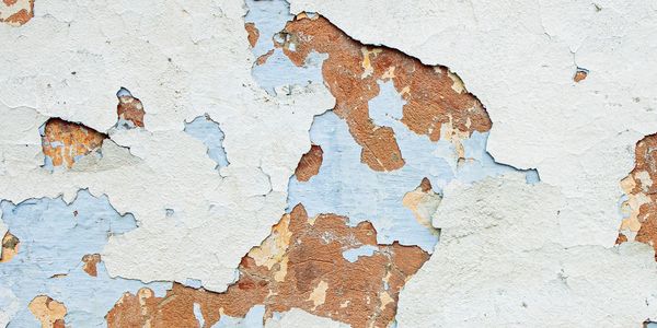 Peeling white paint revealing old, weathered wood underneath.