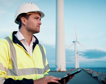 Two cleaners in uniforms with cleaning supplies give thumbs up indoors.