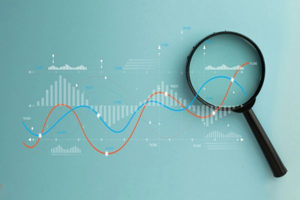 Magnifying glass over financial data charts.
