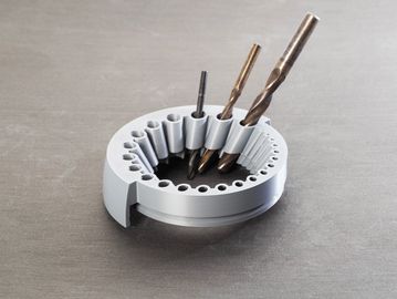 Circular drill bit holder with varying sizes of drill bits organized.