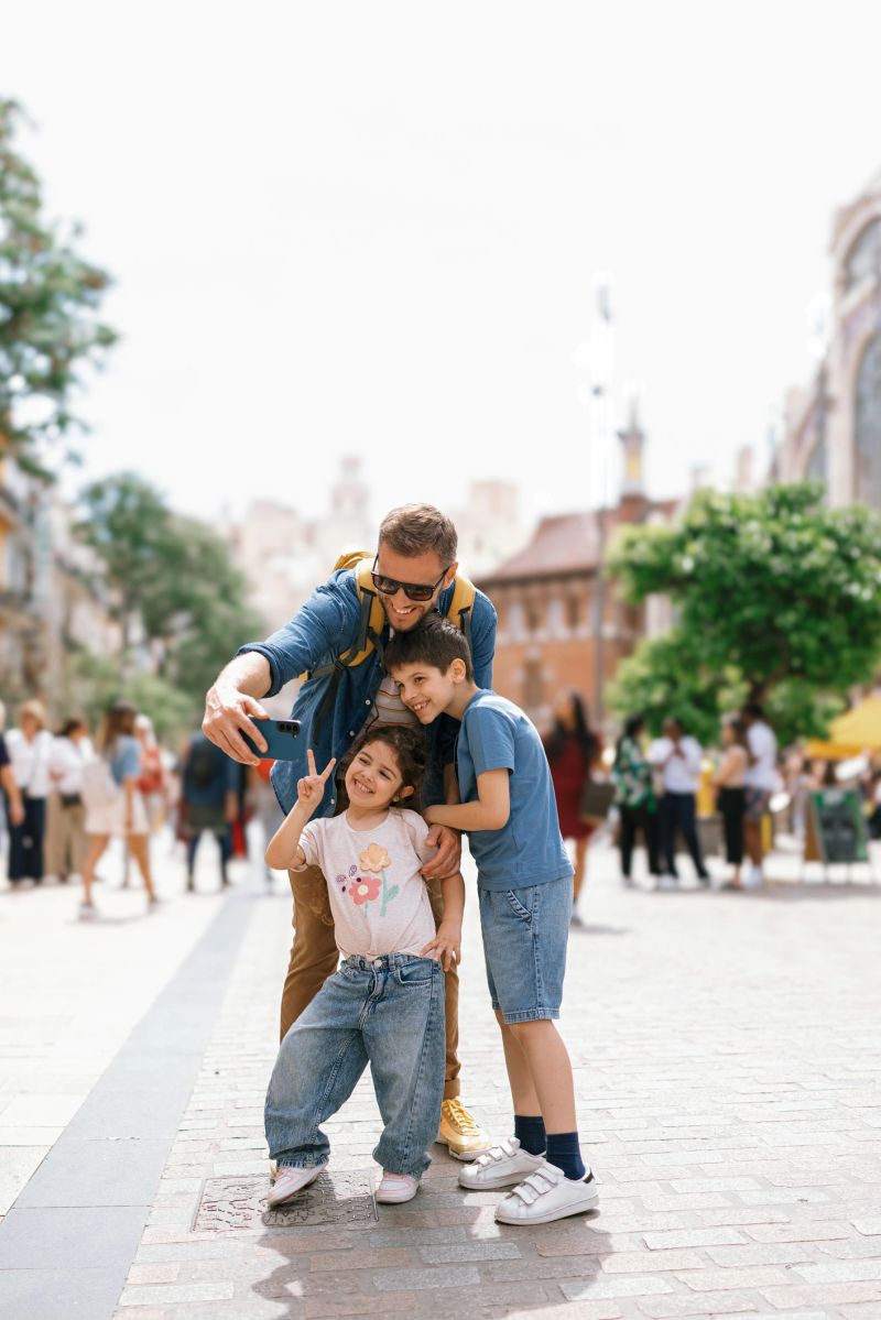 Father taking selfies with children in a pedestrian zone in Valencia