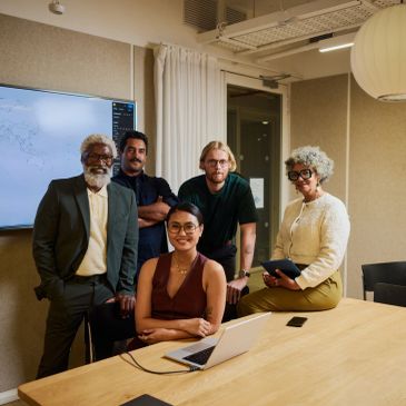 Group of professionals posing together in an office — Organizational Improvement service card descri