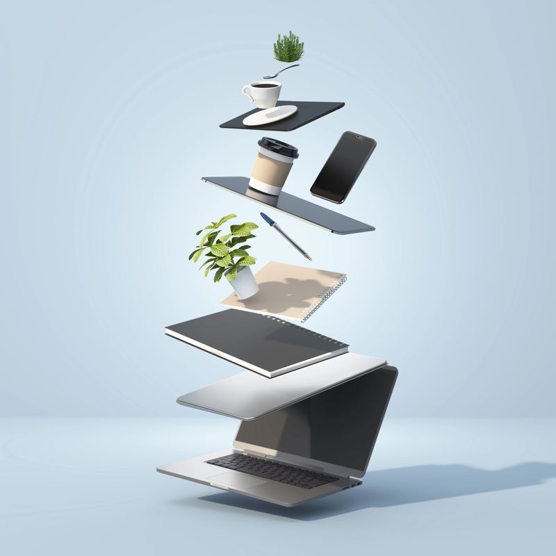 A modern workspace showcases a laptop, notebooks, a coffee cup, a smartphone, and plants floating in an artistic arrangement. The scene inspires creativity and productivity.
