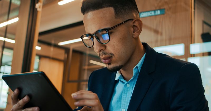 Worker, overtime and digital technology for research, productivity and information of startup connection. Happy businessman, night business and tablet planning in office, online media app and smile.