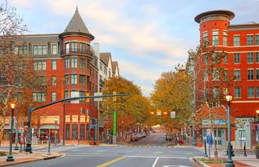 Autumn city street with red brick buildings and fall trees.