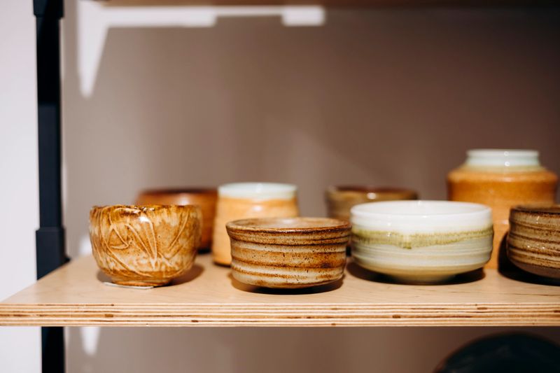 Close-up of handmade ceramic match holders displayed on a store shelf. Perfect for craft shopping, home decor, and gift concept imagery.