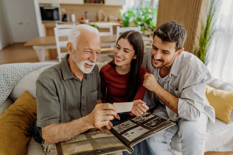 Senior man looking at old photographs with his grandchildren