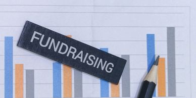 Fundraising theme on a bar chart with a pencil.