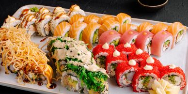 Assorted sushi rolls on a white plate.