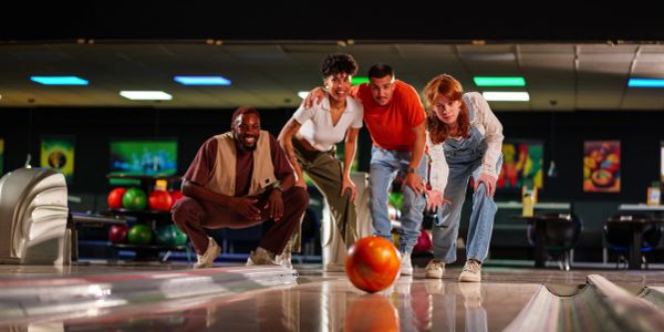 A group enjoys bowling together in a lively alley.