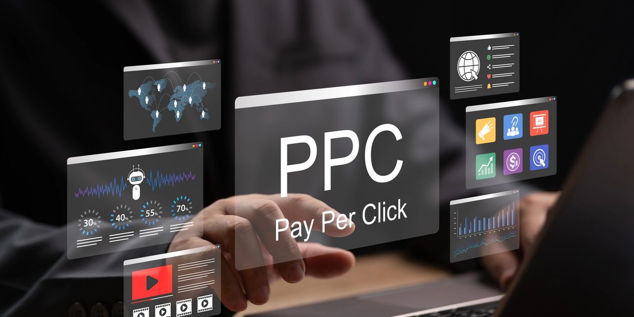 Acronym PPC. Pay Per Click below it. Man on Laptop pointing to PPC (Pay-Per-Click) image.