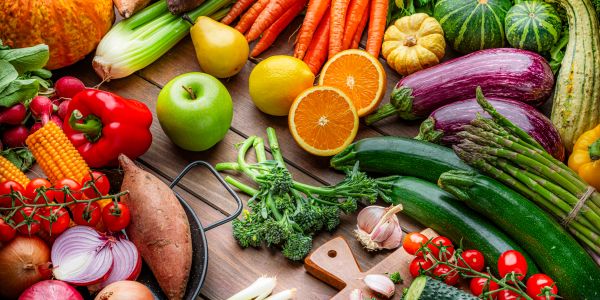 Colorful fresh fruits and vegetables on a wooden table.