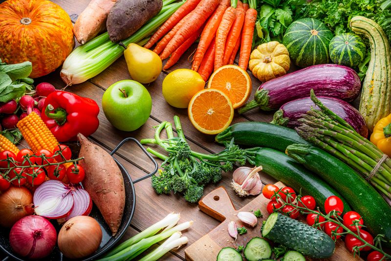 Freshly picked organic fruits and vegetables on kitchen table. Preparing healthy vegetarian meal with juicy ingredients. Food to improve the inmune system.