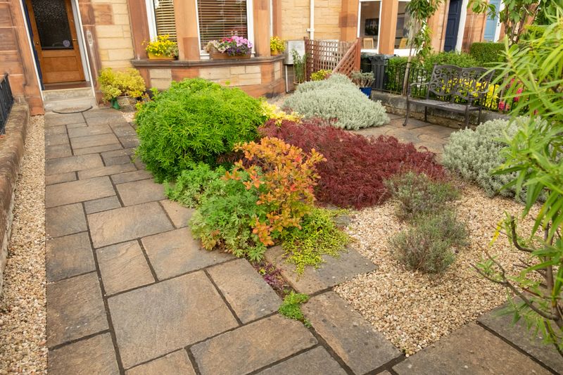 Small front garden of terraced house with path to front door and bench, Edinburgh, Scotland