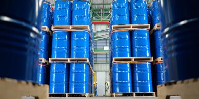 Stacks of blue barrels in a warehouse.