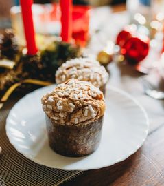 Close-up of a nut-topped muffin on a white plate.