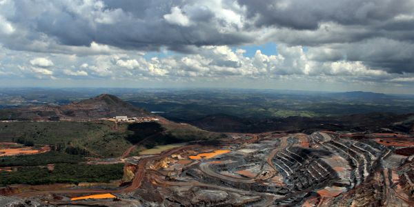 Open-pit mining site under cloudy sky.