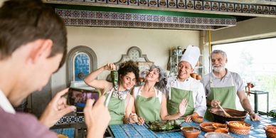 Friends posing for a photo in a kitchen with fresh ingredients.