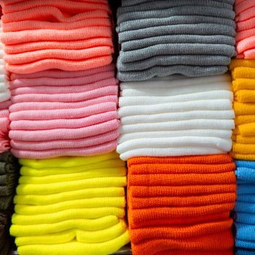 Stacks of colorful knitted fabric neatly arranged.