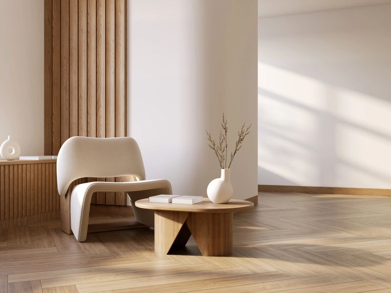 MInimal and warm living room interior with Serene Corner with Natural Light, wooden floors, and an armchair against warm white walls.3d render