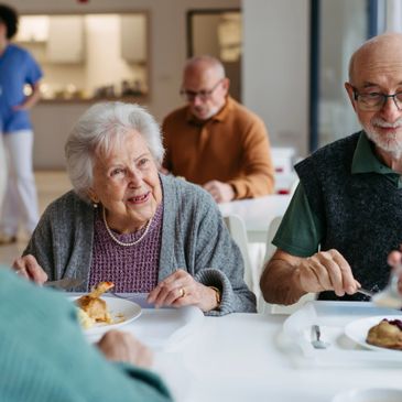 Elderly people eating together and enjoying a meal.