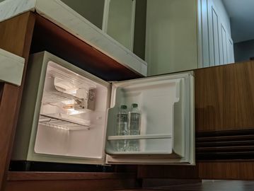 Mini fridge with bottled water under countertop.