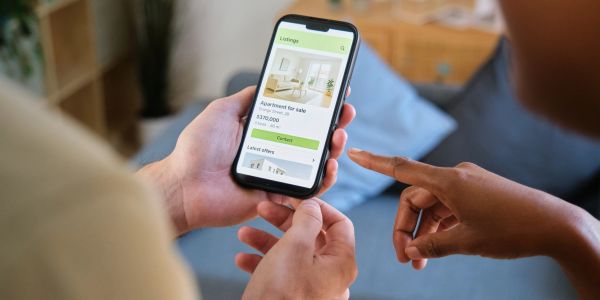 Person browsing apartment listings on phone.