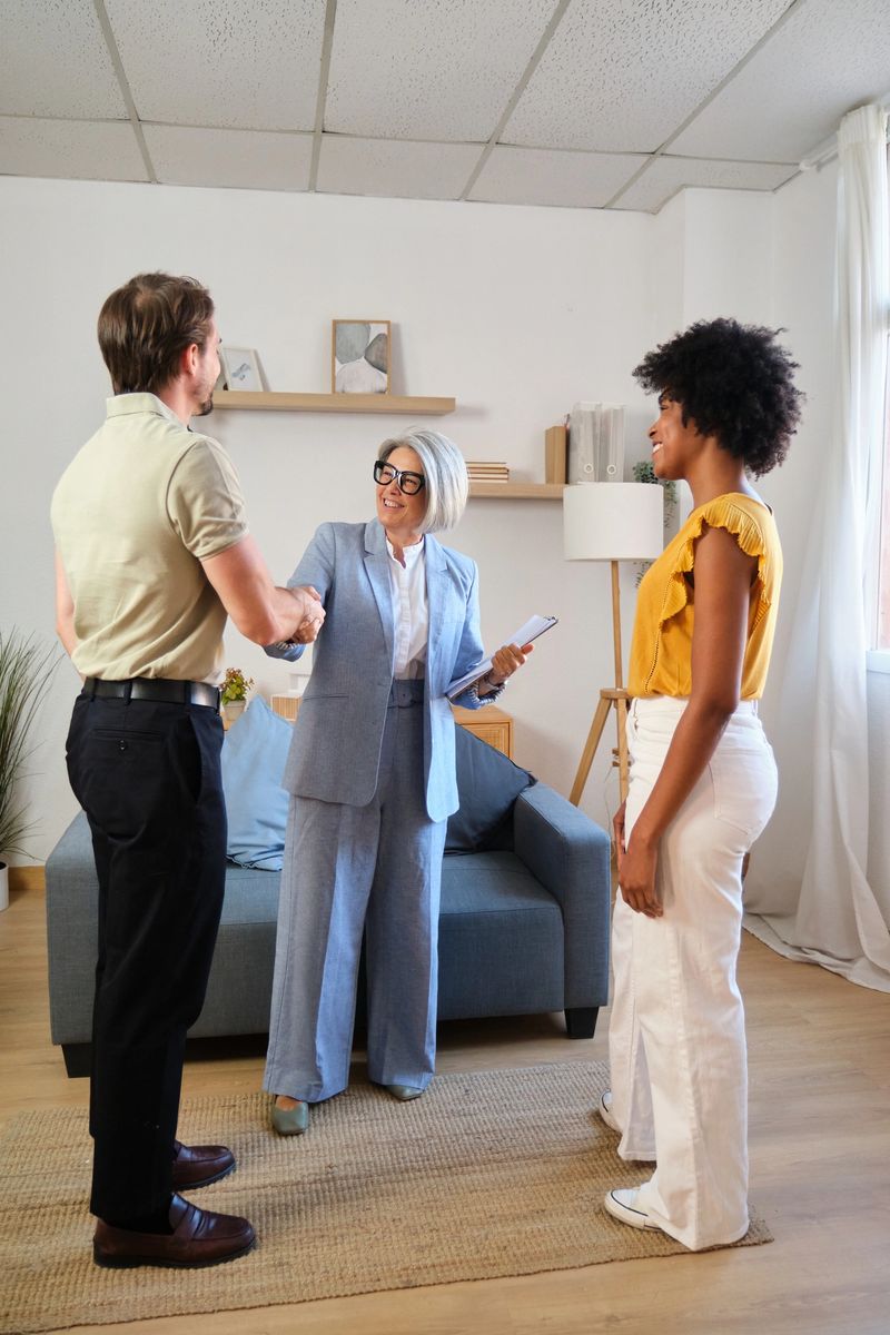 Diverse couple meeting real estate agent in a modern apartment, making an agreement