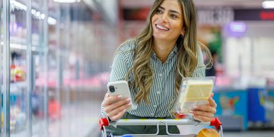 Woman grocery shopping and smiling.